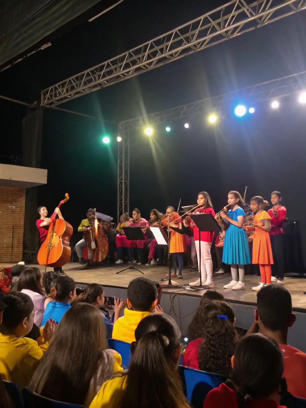 A vibrant scene from a student concert, with performers on stage and an enthusiastic audience, capturing the excitement of the APEC ASS PARENTS D’ELEVES CONSERVATOIRE's performance opportunities.
